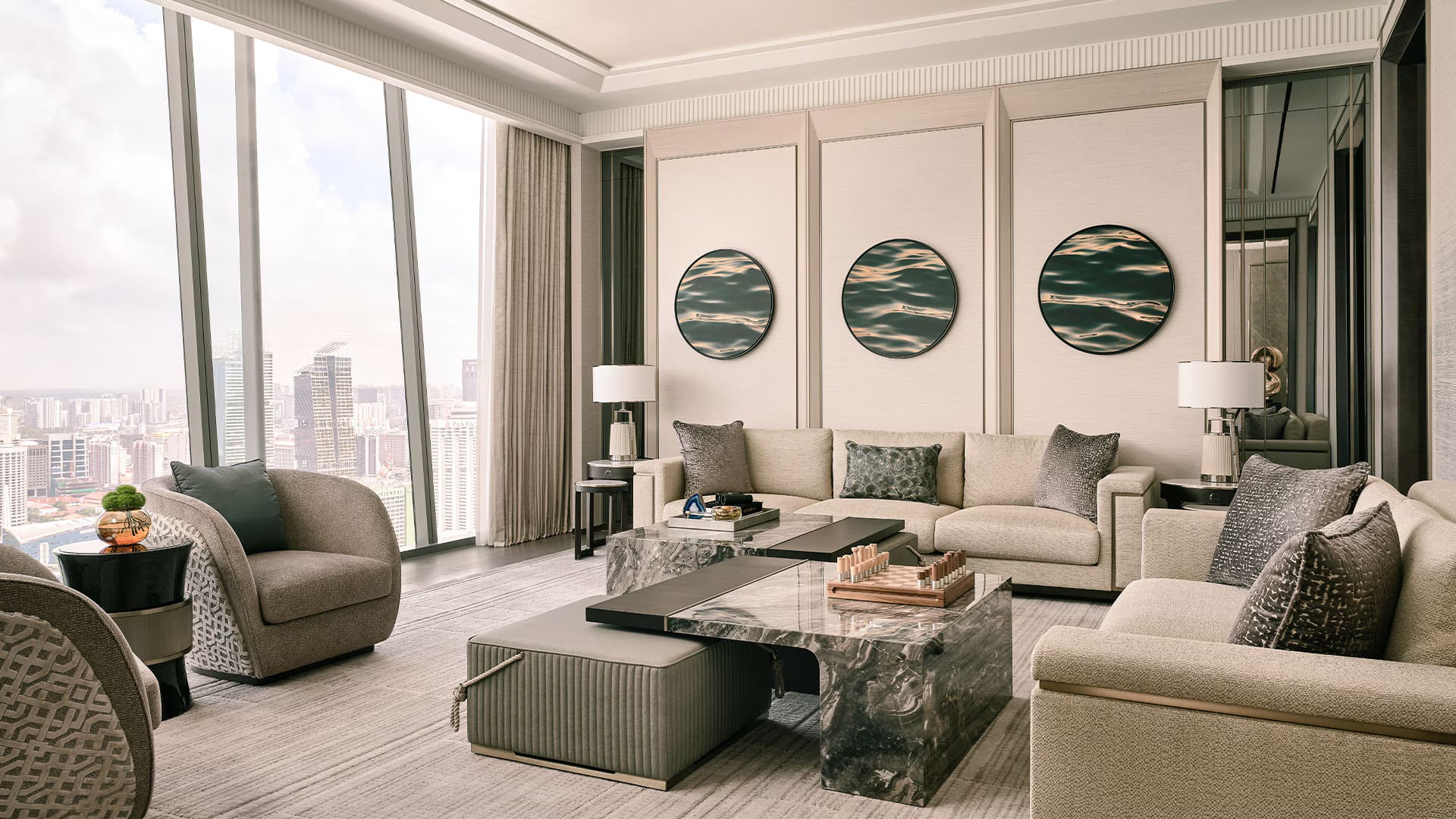 The Horizon suite living room: three circular artworks in marbled greens and whites above a pale sofa, with the city beyond